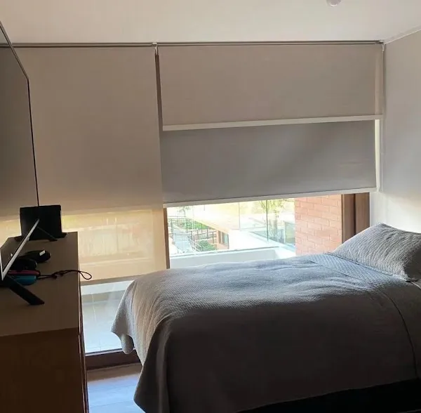 Dormitorio con doble sistema: rollers blackout y traslúcido instalados en la misma ventana